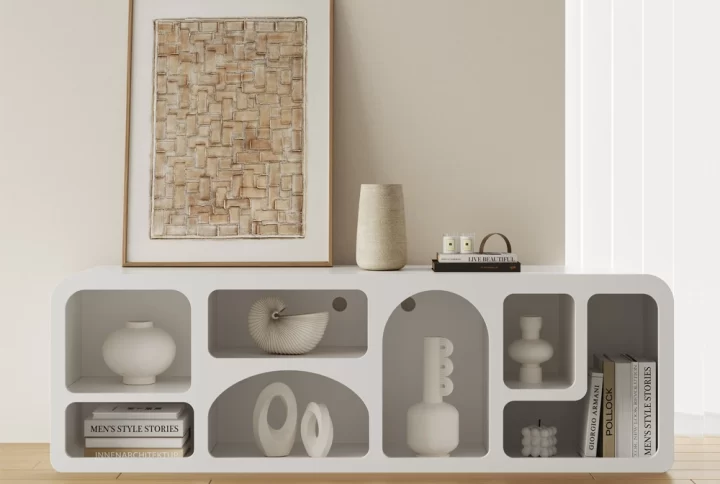 A white art deco bookshelf displaying vases and books, elegantly arranged on a stylish TV unit