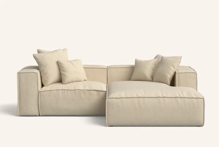 A beige sectional sofa adorned with decorative pillows, providing a cozy and inviting living space.
