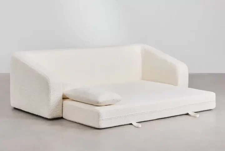 A white couch adorned with a decorative pillow, creating a cozy and inviting living space.