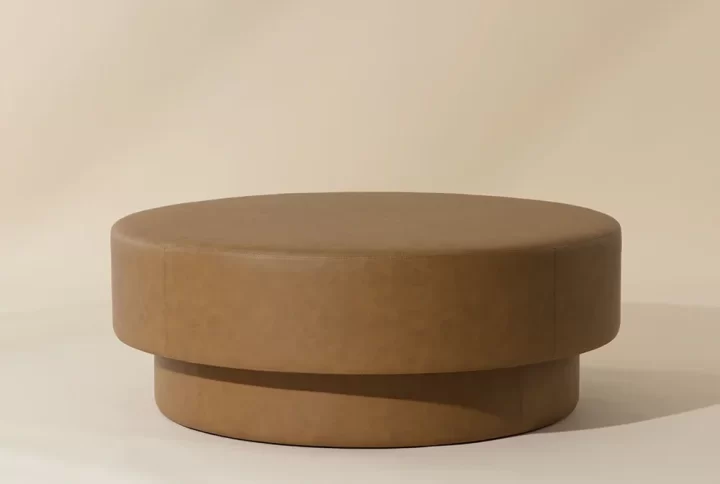 A stylish round brown coffee table with a wooden base, perfect for enhancing the aesthetic of any room
