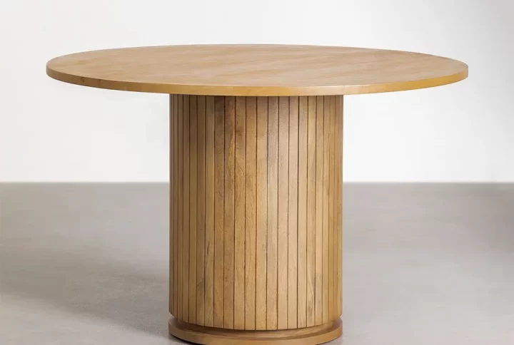 A round wooden dining table with a sturdy wooden base, showcasing a natural finish and elegant design