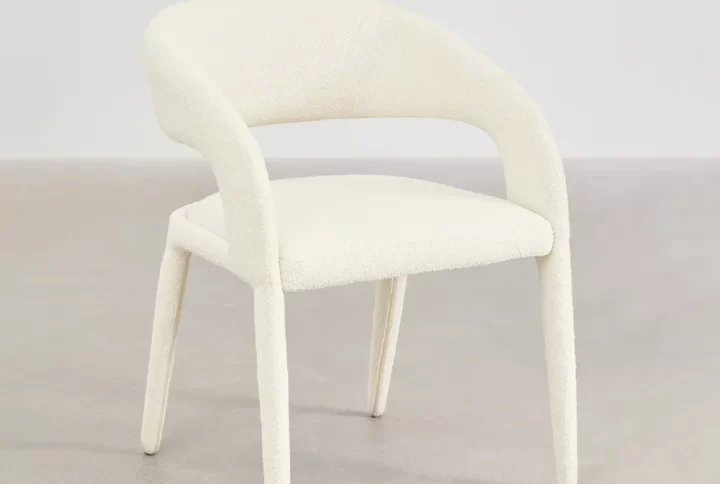 A white chair featuring a gracefully curved back and arms, designed for comfort and elegance in any setting