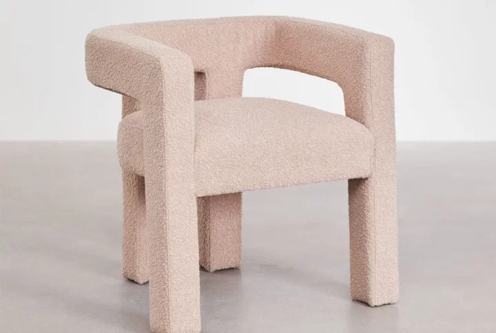 A Pink chair featuring a gracefully curved back and arms, designed for comfort and elegance in any setting