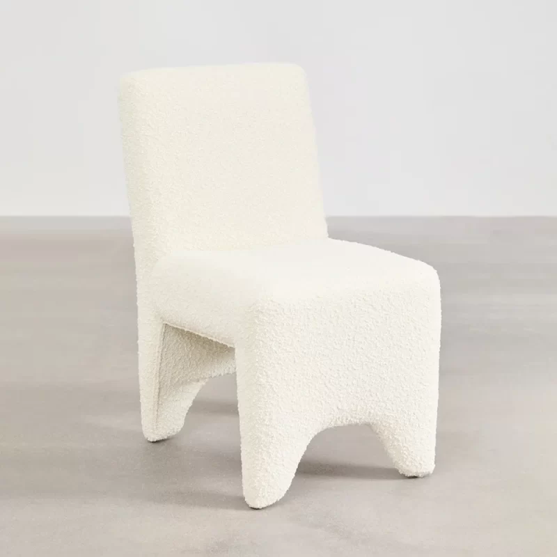 A simple chair and table positioned in front of a plain wall, creating a minimalist setting