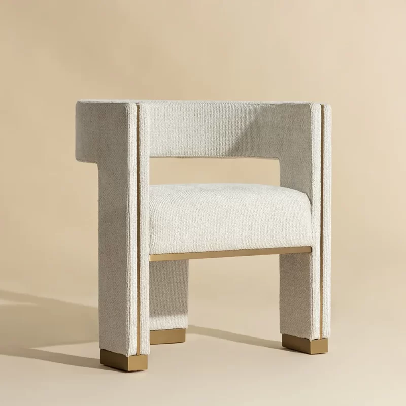 A modern chair featuring beige fabric upholstery and elegant gold legs, showcasing a stylish and contemporary design
