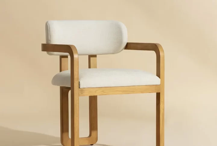 Capucine Dining chairs will stun from all angles. The curved lines of the three-legged brown oak wood frame lend a statuesque presence to any room. The low back seat is upholstered in heather ivory fabric for luxurious comfort. Performance fabric is moisture repellent