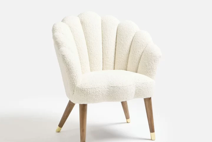 A white shell chair featuring elegant gold legs, showcasing a modern and stylish design suitable for any interior space