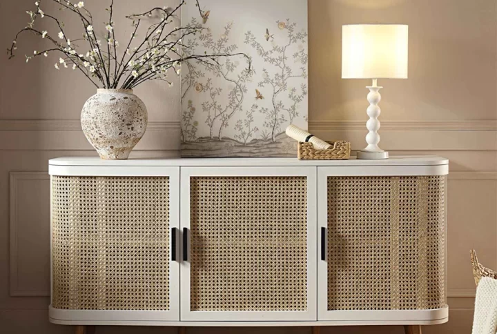 A white sideboard adorned with a lamp, positioned on a decorative rug, creating a stylish interior setting
