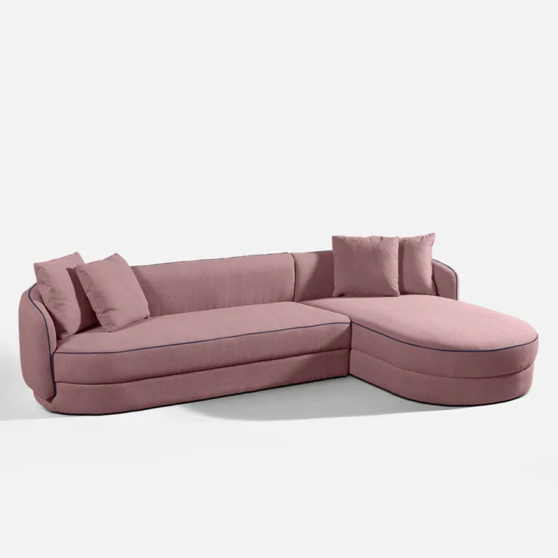 A pink sectional sofa adorned with decorative pillows, showcasing a cozy and inviting living room setting