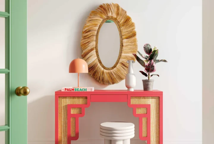 A bright green console table with a mirror above it and a matching stool beside it