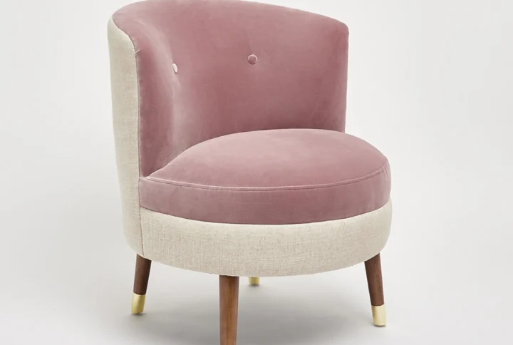 Dusty Pink Velvet Accent Chair with curved silhouette and gold-accented tapered legs styled in bedroom