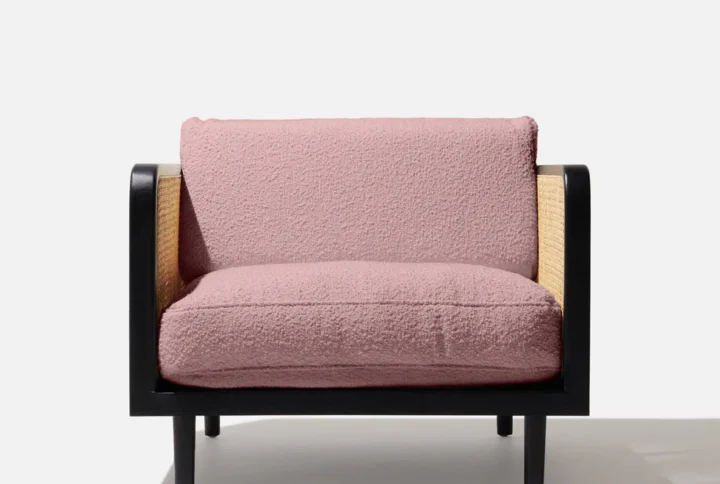 Fly Rattan Armchair with mango wood frame and rose gold bouclé upholstery in modern living room