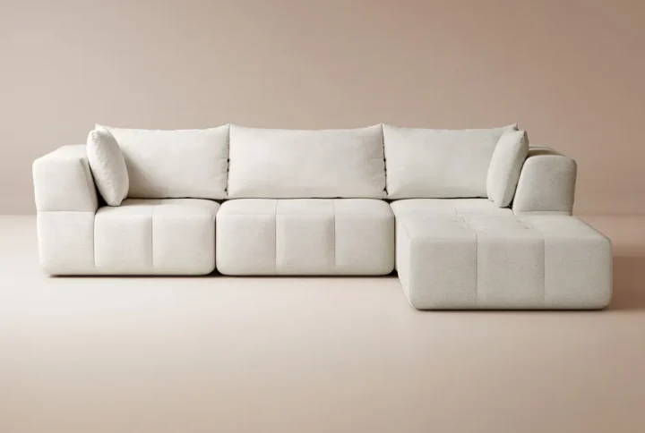 A cozy living room featuring a white couch and a wooden table, creating a warm and inviting atmosphere.