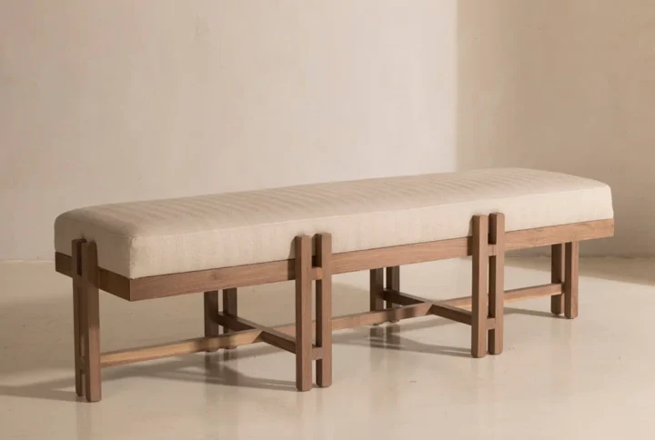 Minimalist Wooden Bench with cushioned beige seat and cross-braced natural wood legs.