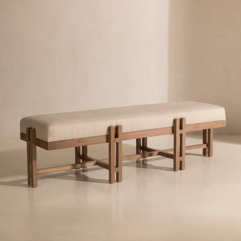 Minimalist Wooden Bench with cushioned beige seat and cross-braced natural wood legs.