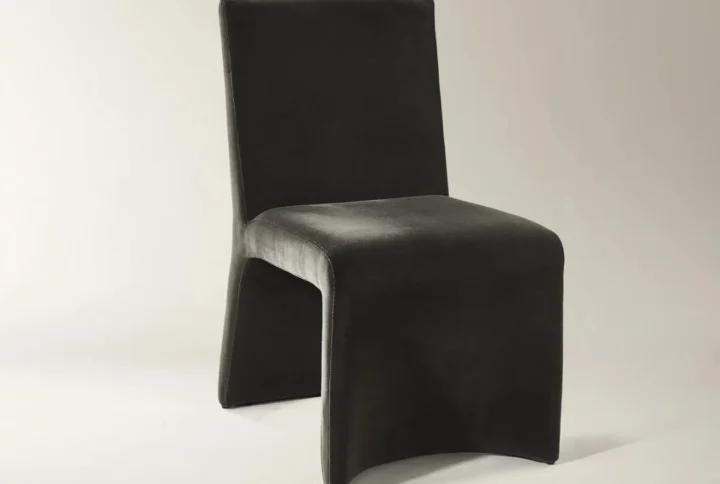 Black minimalist accent chair with rectangular backrest and sculptural base featuring curved cutout.