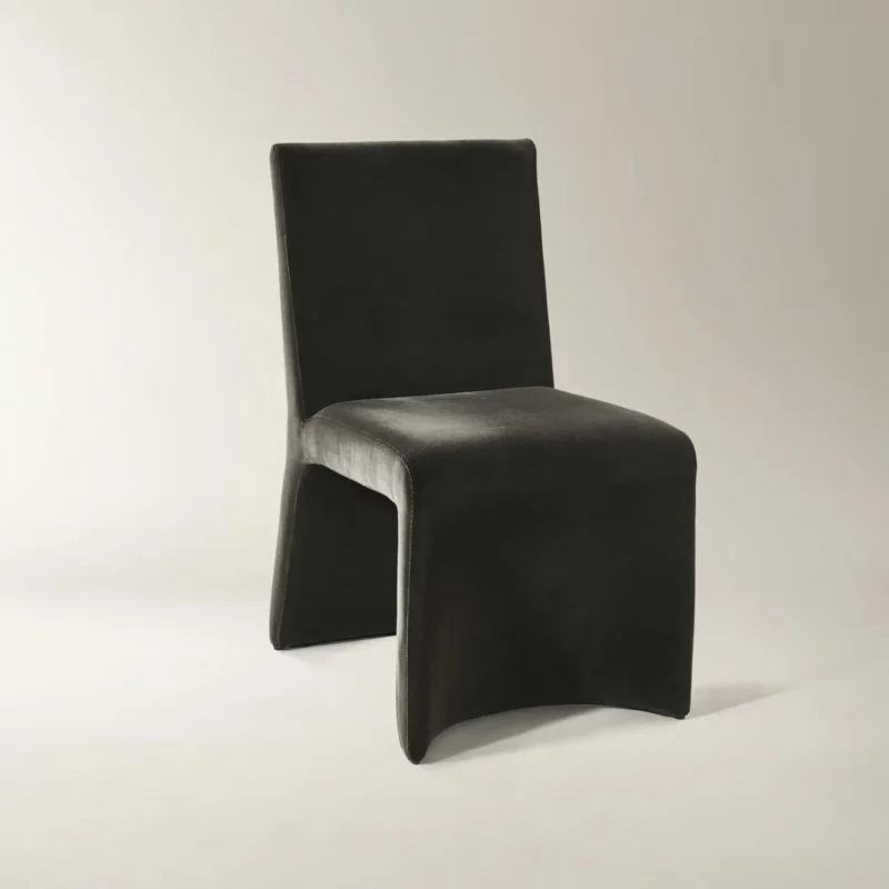 Black minimalist accent chair with rectangular backrest and sculptural base featuring curved cutout.