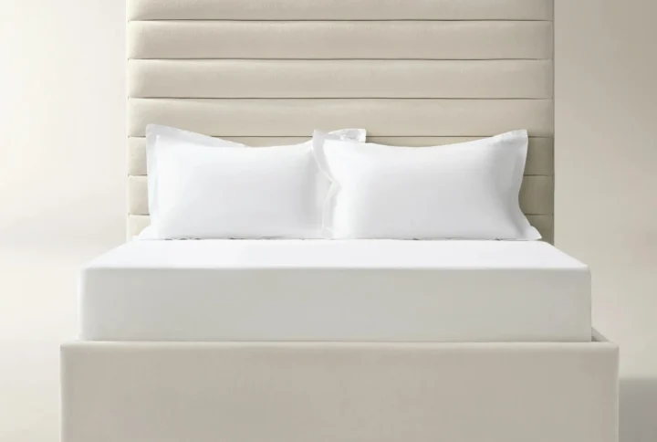 Light beige upholstered bed with horizontal channel-tufted headboard and white bedding in modern bedroom setting