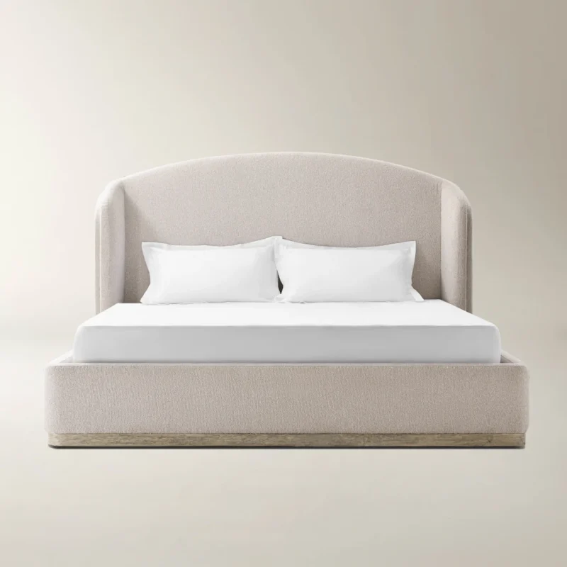 Light beige upholstered bed with curved headboard, wooden base accent, and minimalist styling.