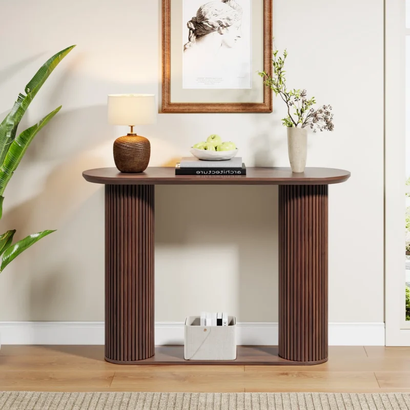 Wooden console table with grooved legs, styled with lamp, vase, book, and decorative bowl in modern interior.