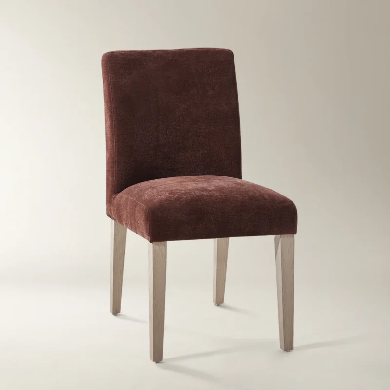 Modern burgundy upholstered dining chair with curved backrest and light wood legs.